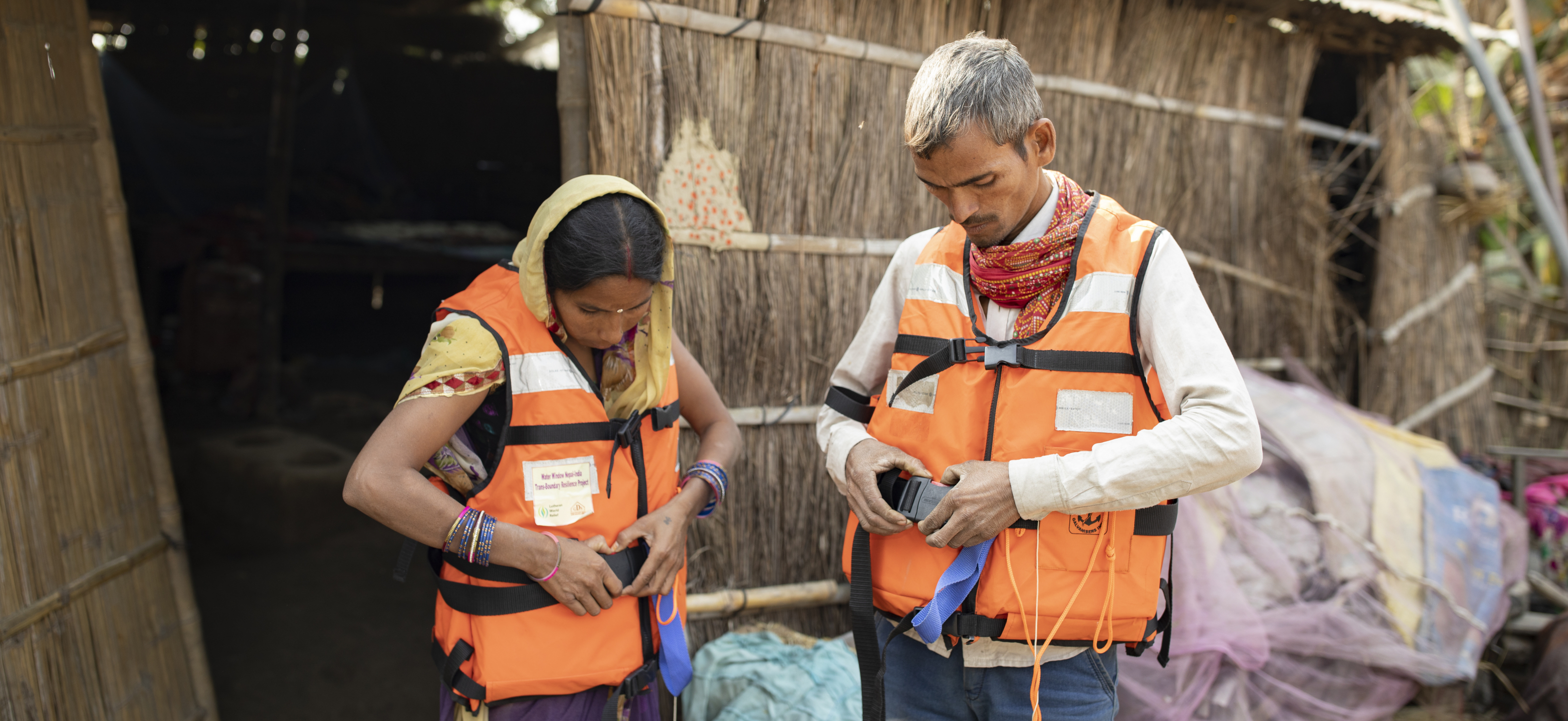 Nikky Devi and her husband Rajendra Kushwaha put on life jackets in a flood-preparation drill outside their home in West Champaran District, Bihar, India as part of Lutheran World Relief’s Congregational Transboundary Flood Resilience project.