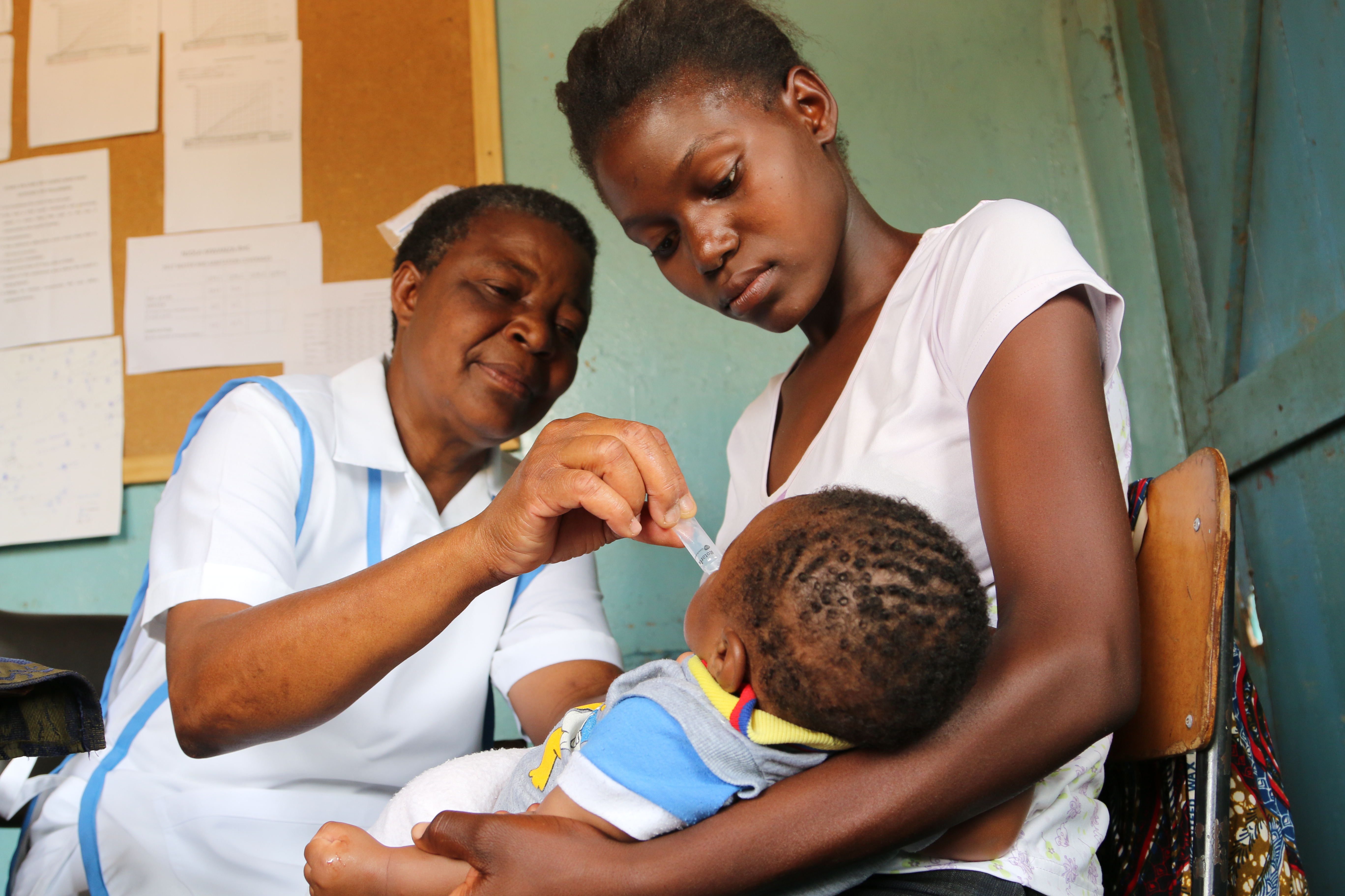 Nurse Lennie N'guni, 60, administers an anti-diarrhoea vaccine to a baby held by his mother Virginia, 18, at Mwanza Clinic in Monze District, Zambia.