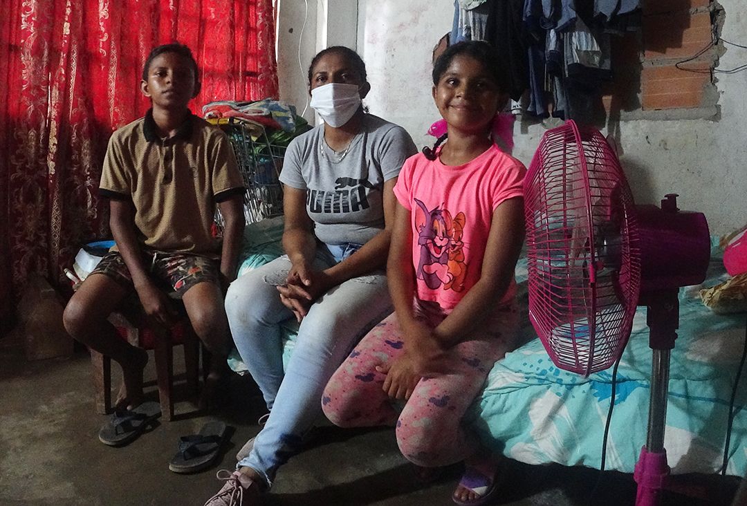Eva del Rosario Escalona sits with her 13-year-old son Daniel and 12-year-old daughter Elianis in their new home in Colombia.