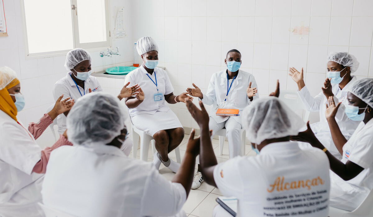 Nurses taking part in a birth simulation training at Nacala Porto Hospital come together for a group session.