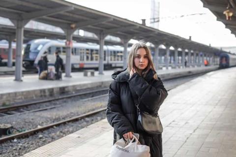 Katy waits in a train station in Bucharest, Romania, unsure what the future holds for her.