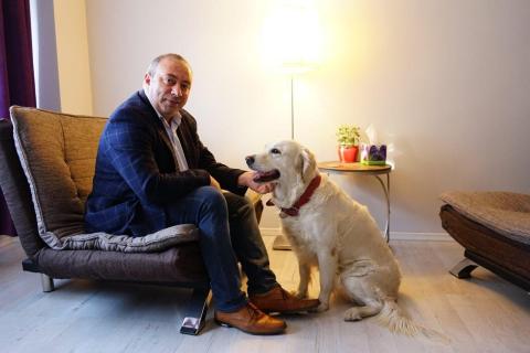 Dr. Florian Koleci in his office with a client's dog